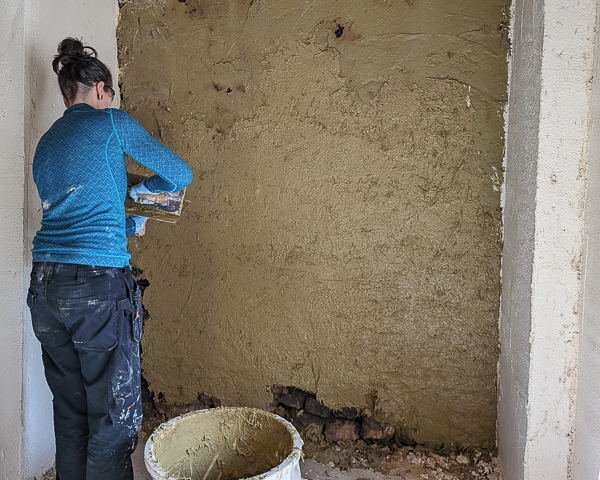 Jen Langfield applying cow dung plaster to the interior walls